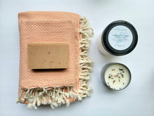 Load image into Gallery viewer, Coral set of Turkish bath and hand towels with tassels, a bar of soap, a eucalyptus mint bath salts, and a lavender sage candle on a white background.