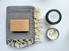 Load image into Gallery viewer, Slate gray set of Turkish bath and hand towels with tassels, a bar of soap, a eucalyptus mint bath salts, and a lavender sage candle on a white background.
