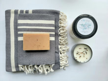 Load image into Gallery viewer, Slate gray set of Turkish bath and hand towels with tassels, a bar of soap, a eucalyptus mint bath salts, and a lavender sage candle on a white background.
